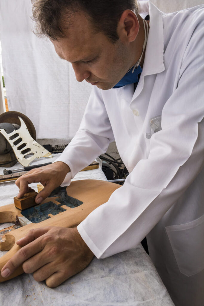 Luthier perassoli lixando corpo de guitarra